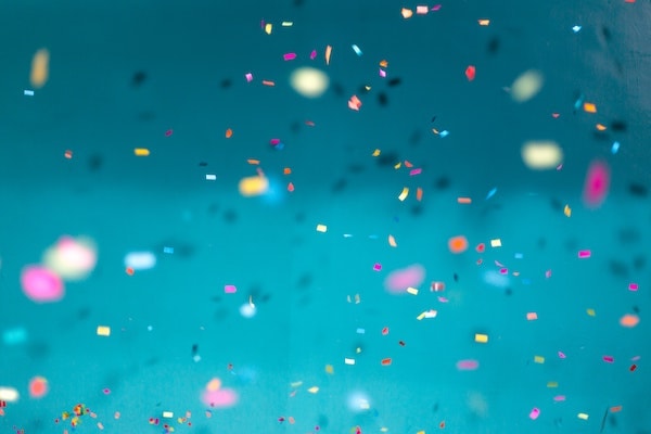 A hand holding confetti in celebration